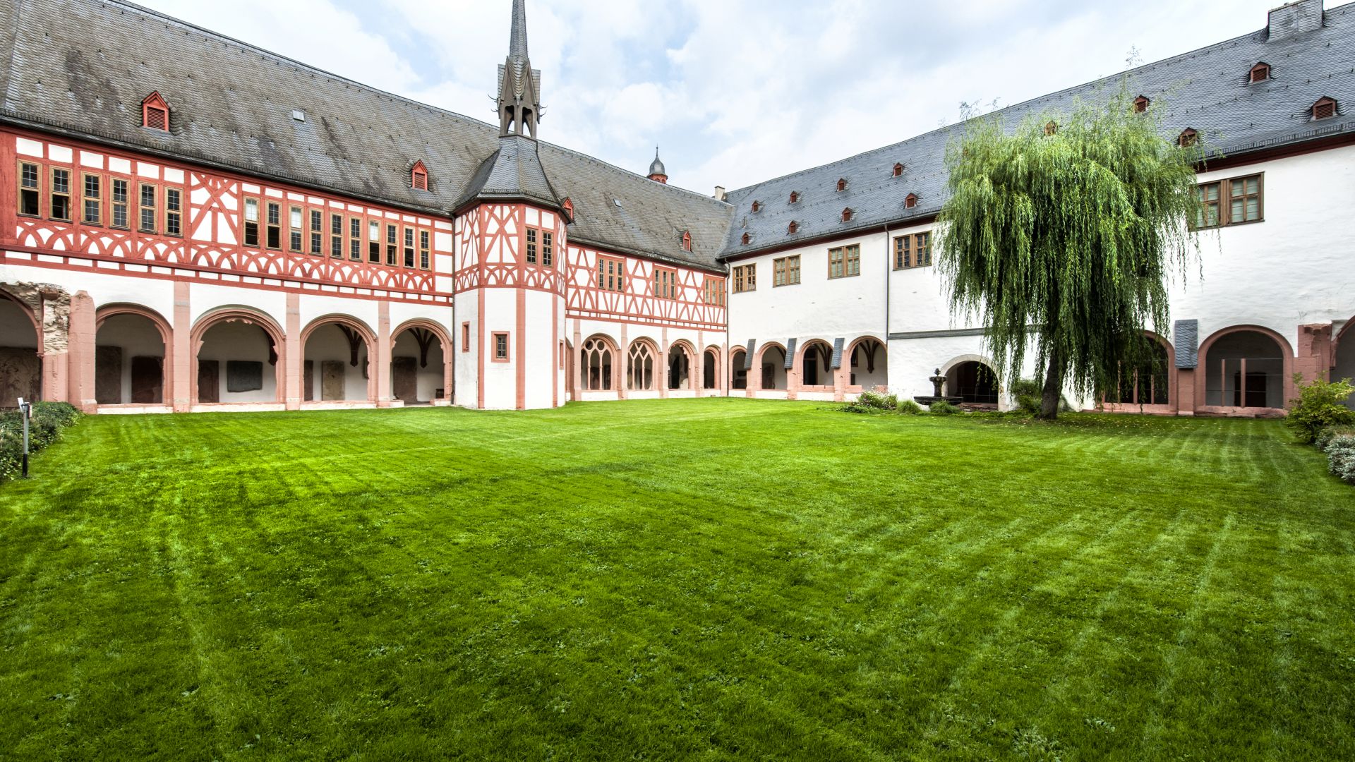 Patio interior del Kloster Eberbach con césped bien cuidado y arquitectura de entramado de madera en Rheingau.