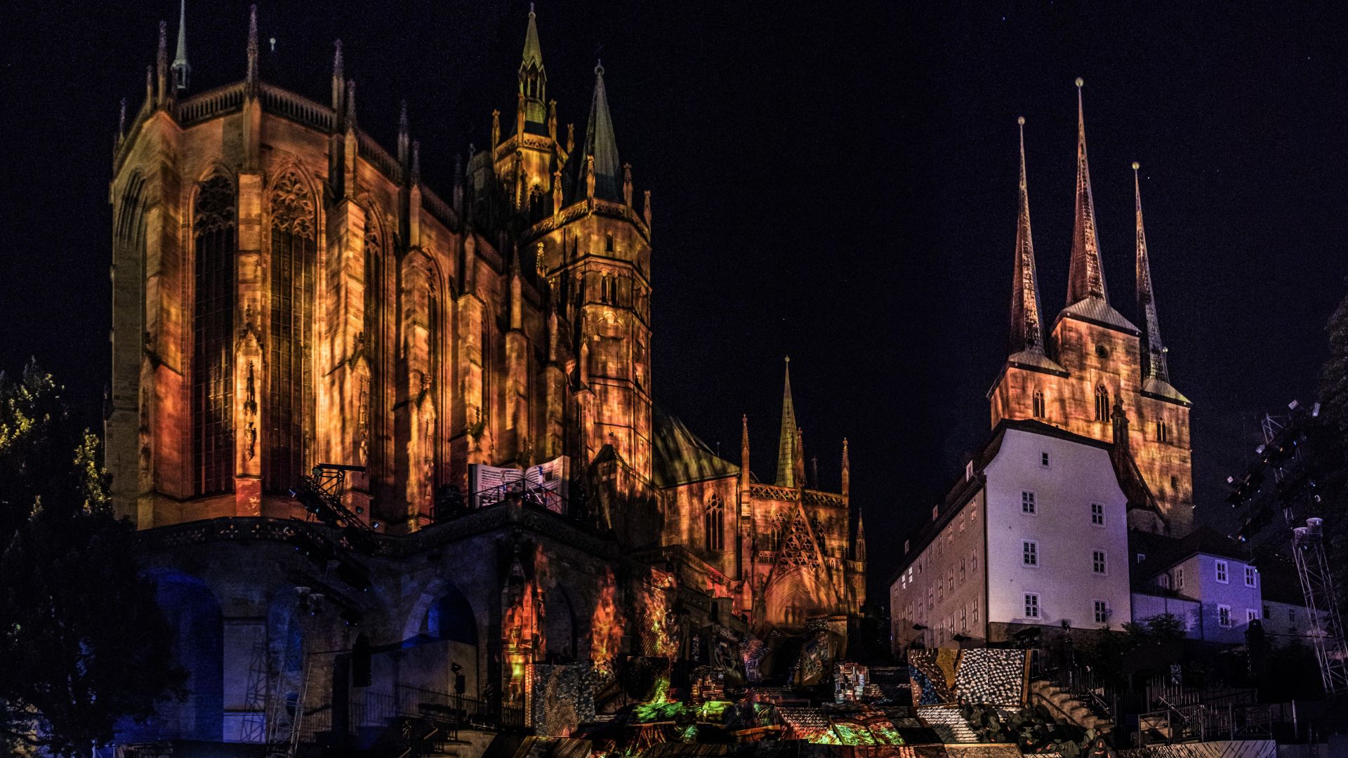 Beleuchteter Dom und Treppen bei den Domstufen-Festspielen in Erfurt, Figuren auf der Bühne.