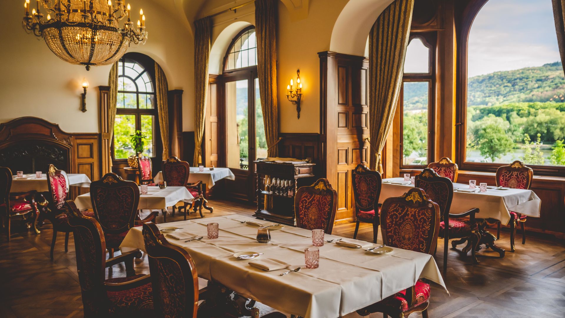 Prunkvolles Restaurant mit Kronleuchter und Blick auf die Mosellandschaft im Schloss Lieser.