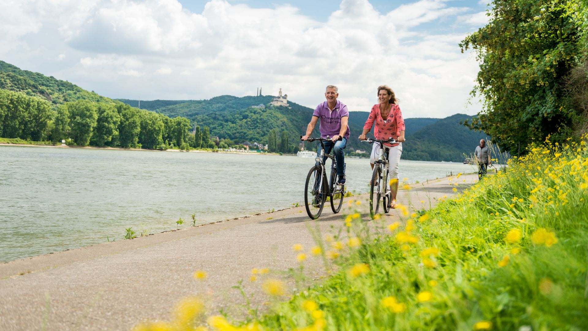Brey: Couple riding bicycles along the river Rhine